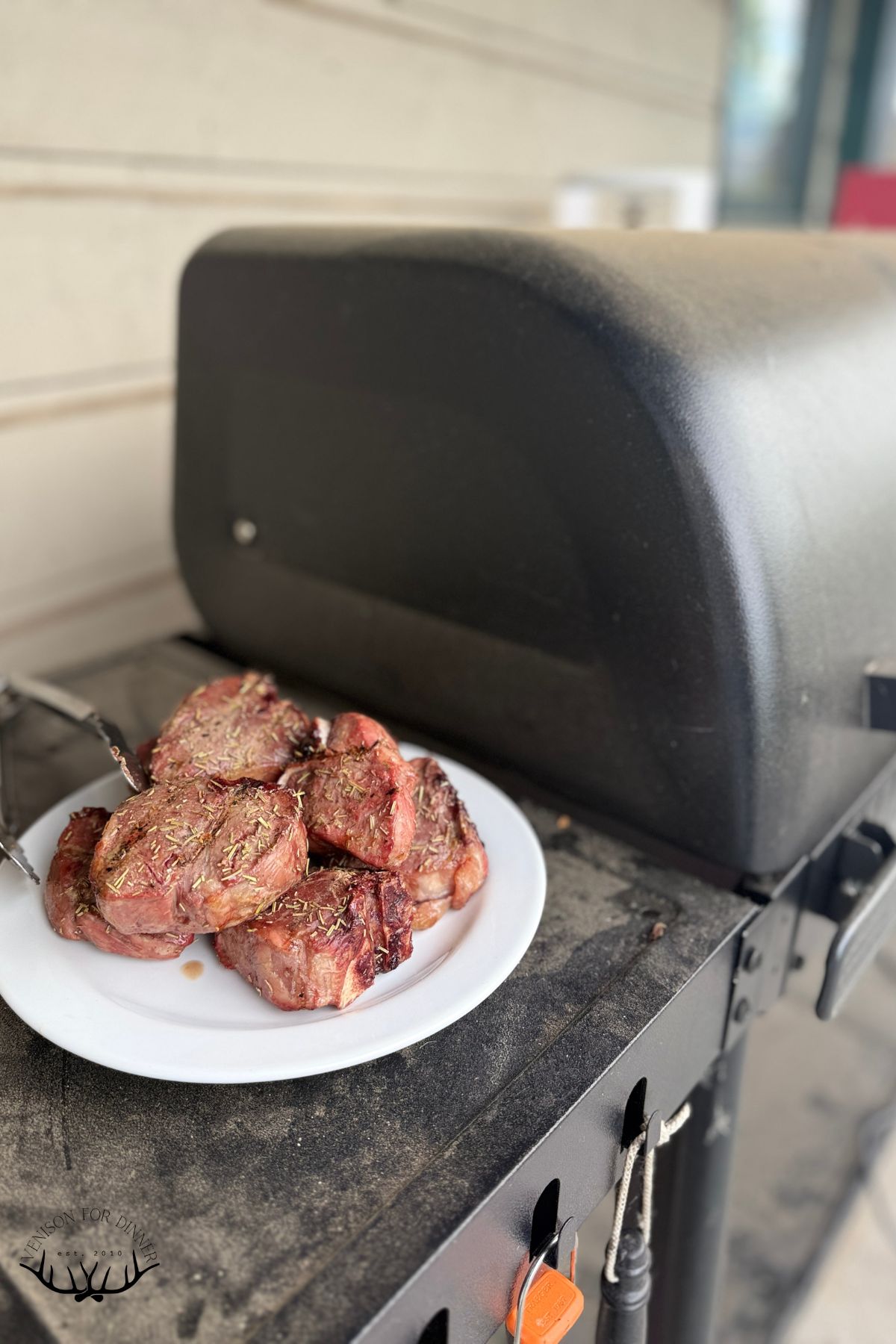 Plate of lamb chops next to a Traeger.