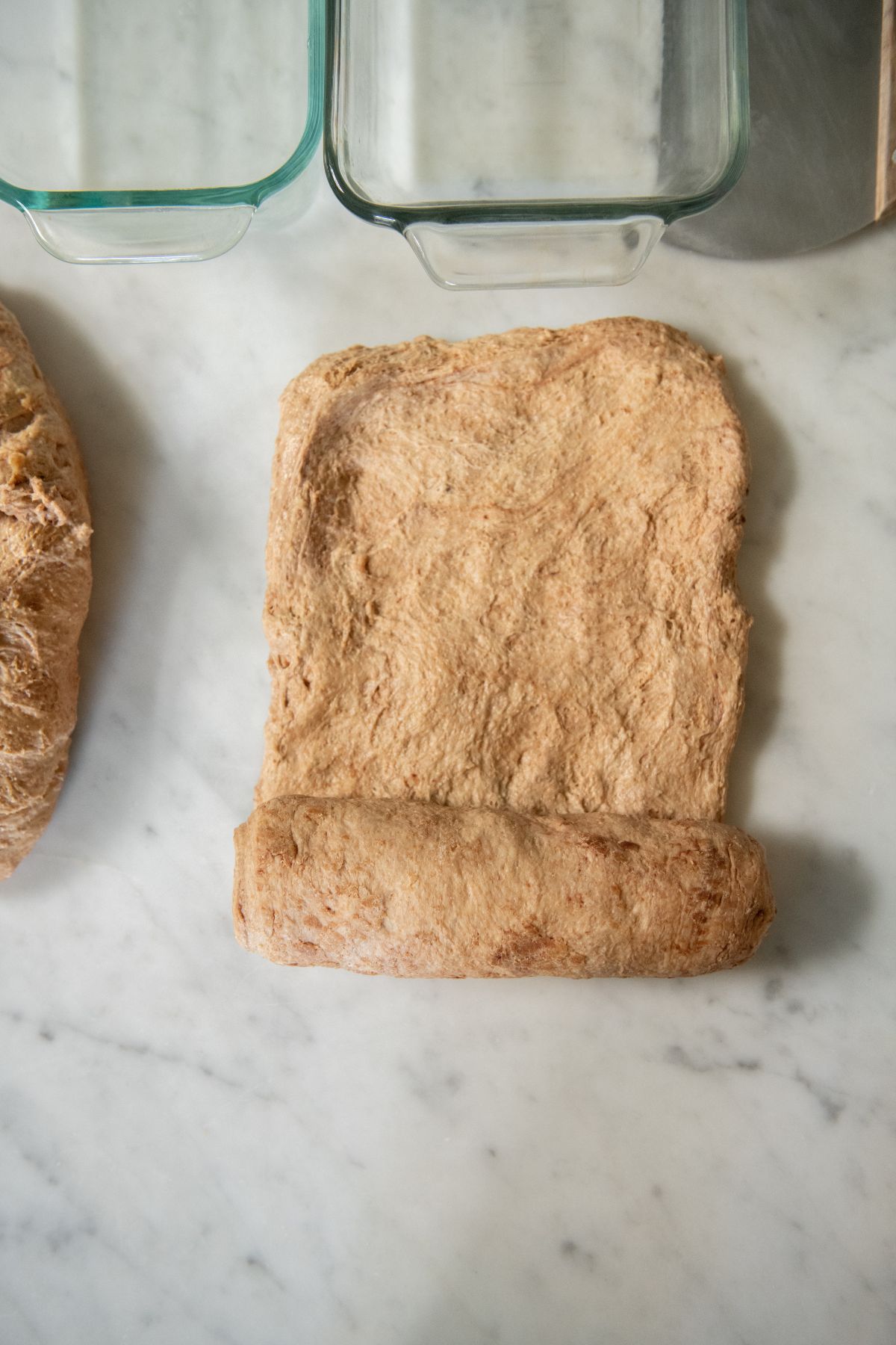 Rolling up a dough rectangle into a loaf.