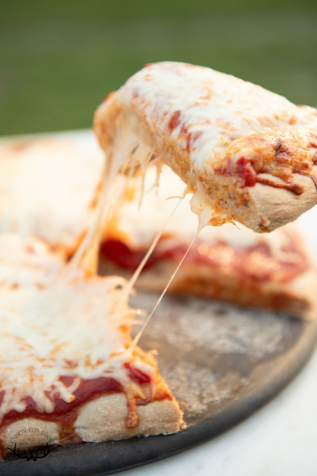 Slicing a cheese pizza.