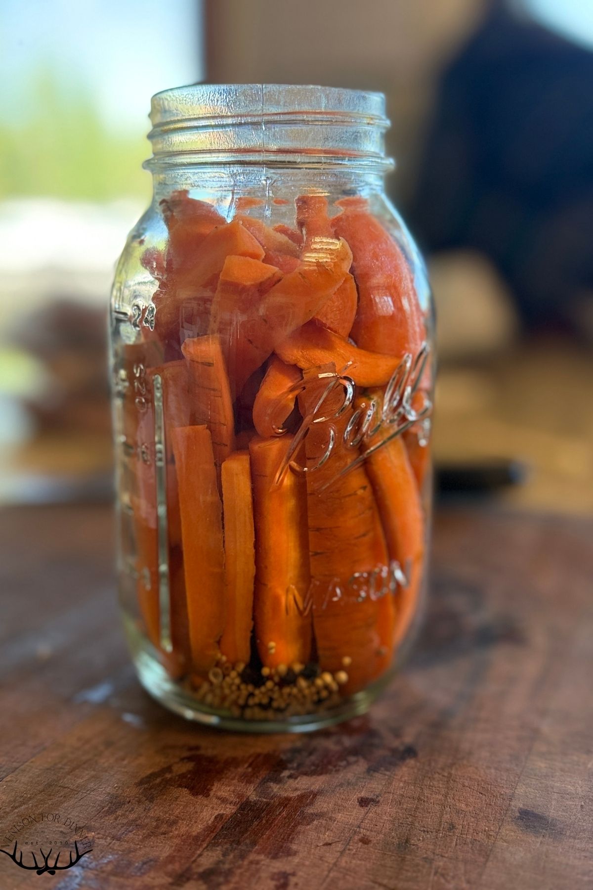 Carrot sticks tightly packed in a Mason jar.