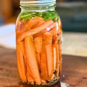 Jar of fermented carrots with mustard seed.