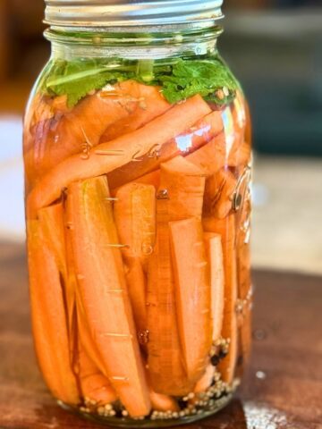 Jar of fermented carrots with mustard seed.