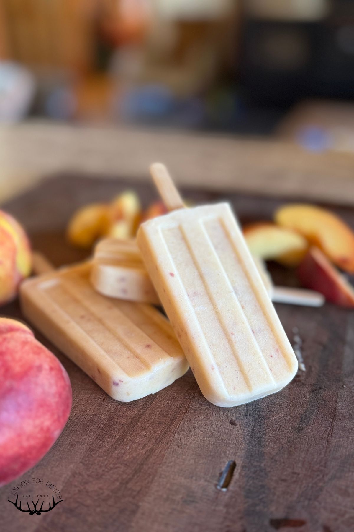 Peach popsicles on a wooden board.