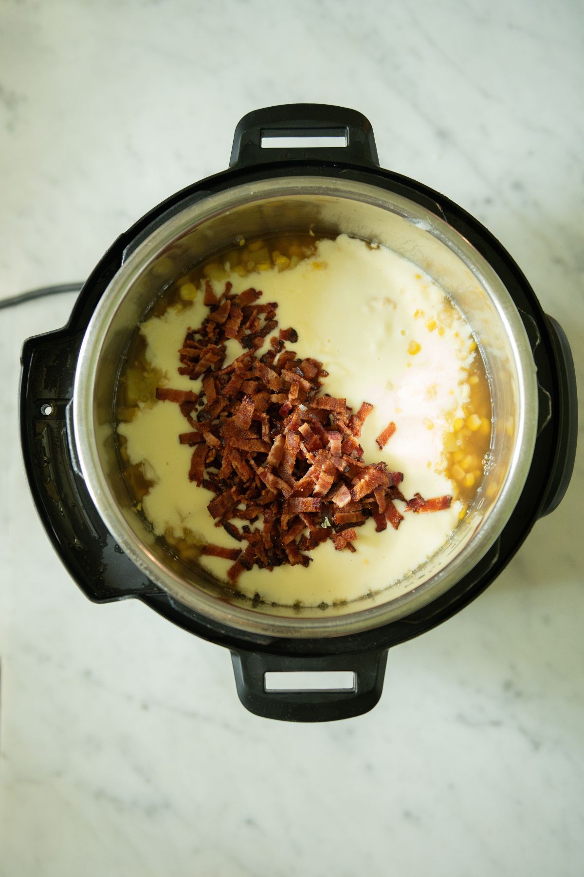 Stirring bacon into finished soup.