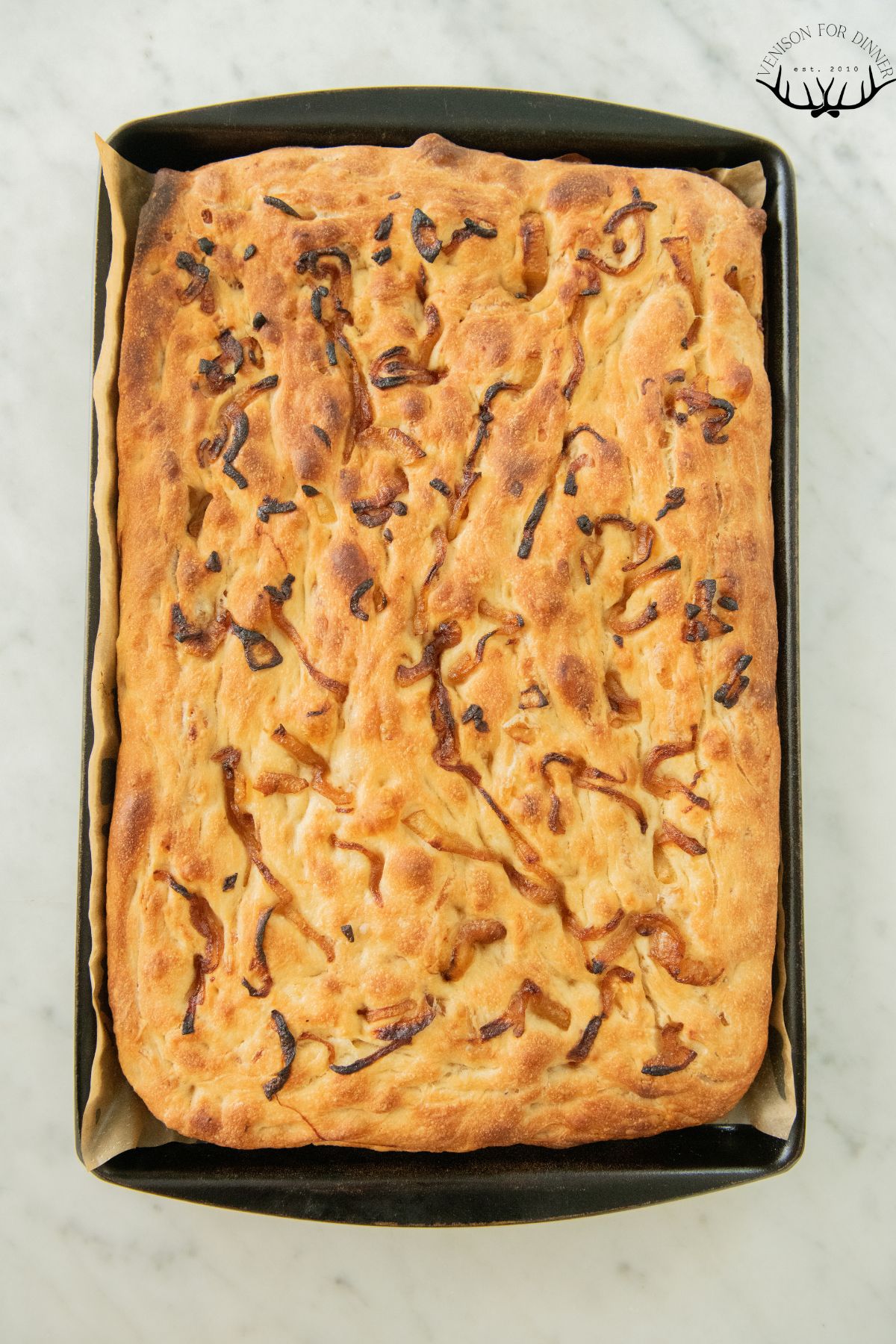 A pan of baked caramelized onion focaccia.