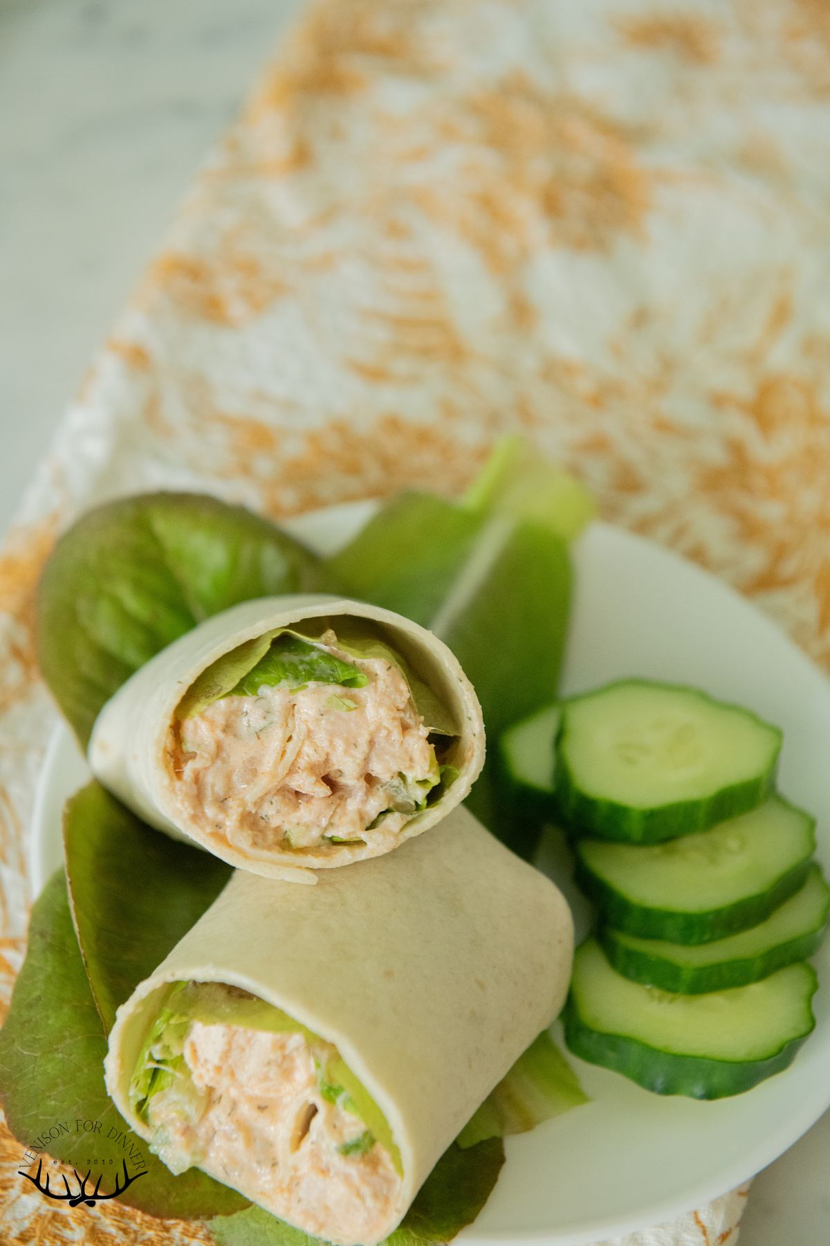 A buffalo chicken salad wrap with cucumbers.