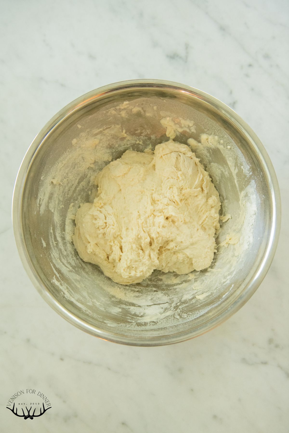 Bread dough ball in a mixing bowl.