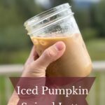 Hand holding a jar of iced pumpkin spice latte.