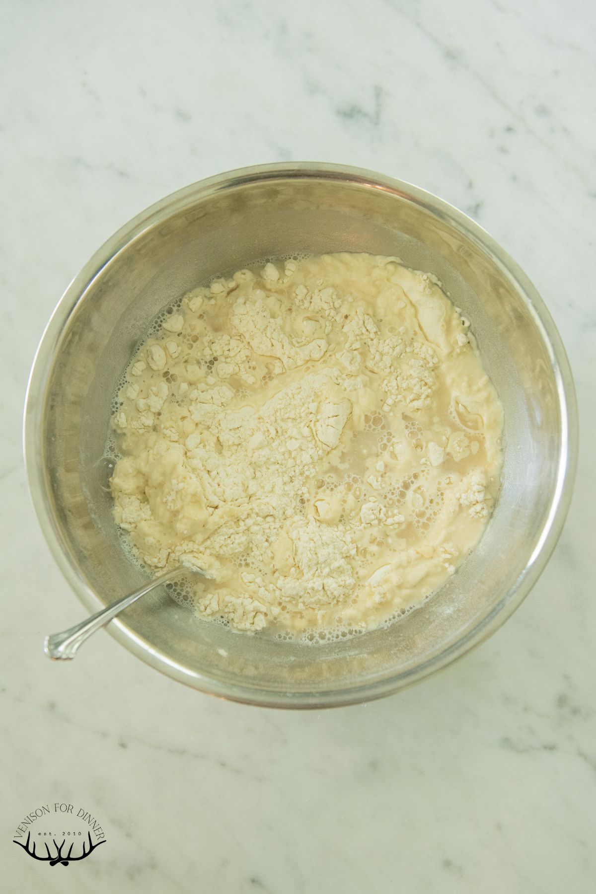 Flour with a spoon in a mixing bowl.