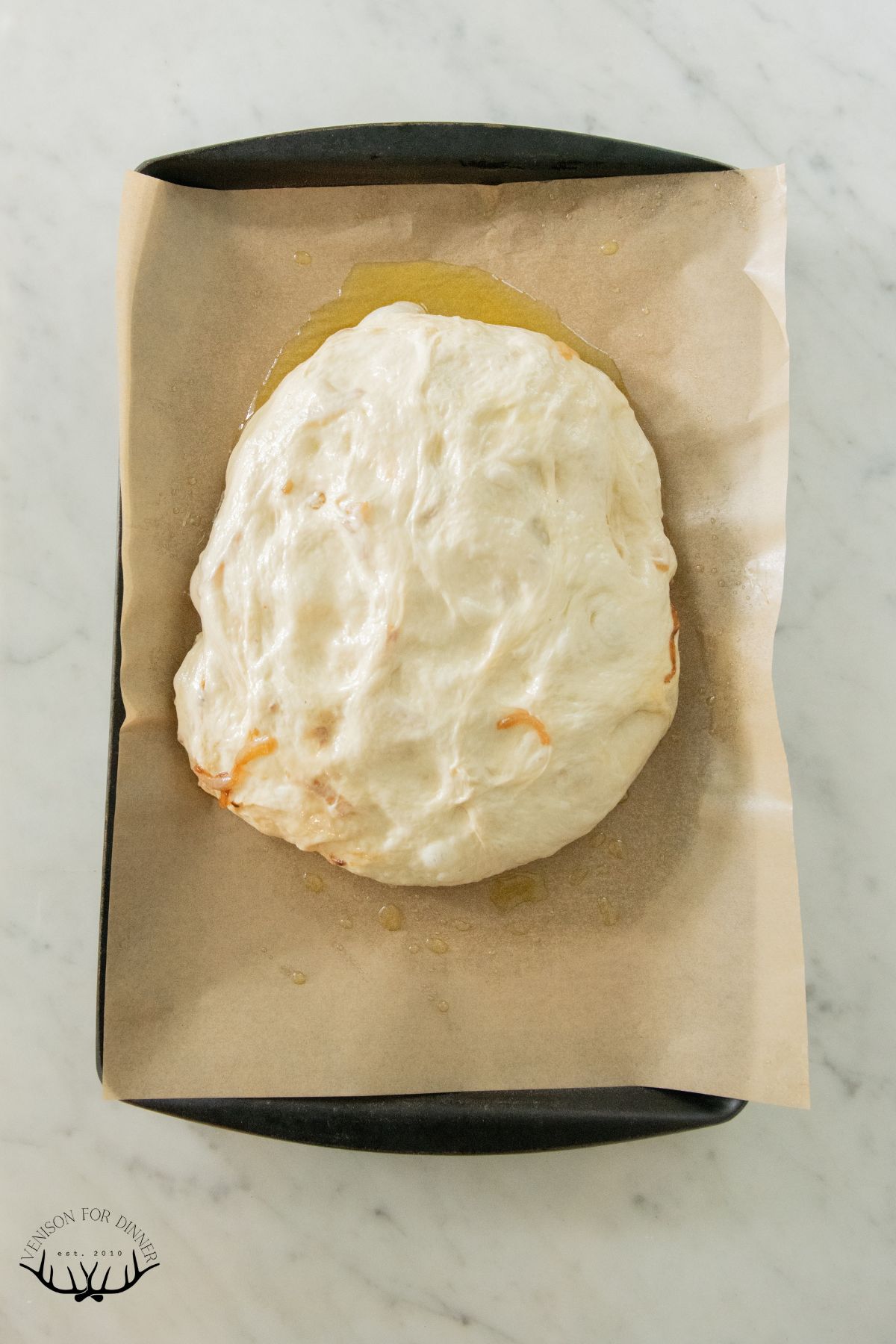 Focaccia dough on a sheet pan.