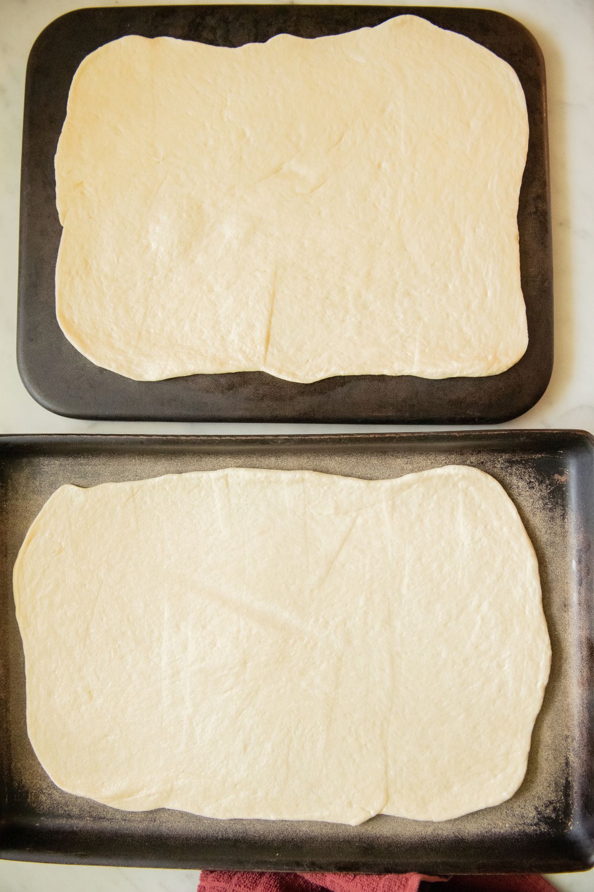 Pizza dough pressed out on a pan.