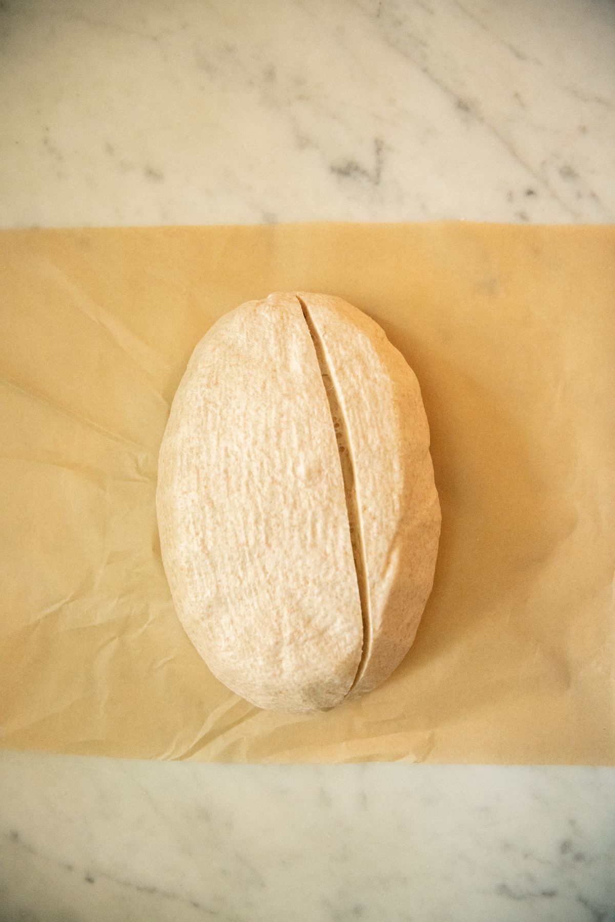 Scored loaf of spelt sourdough.