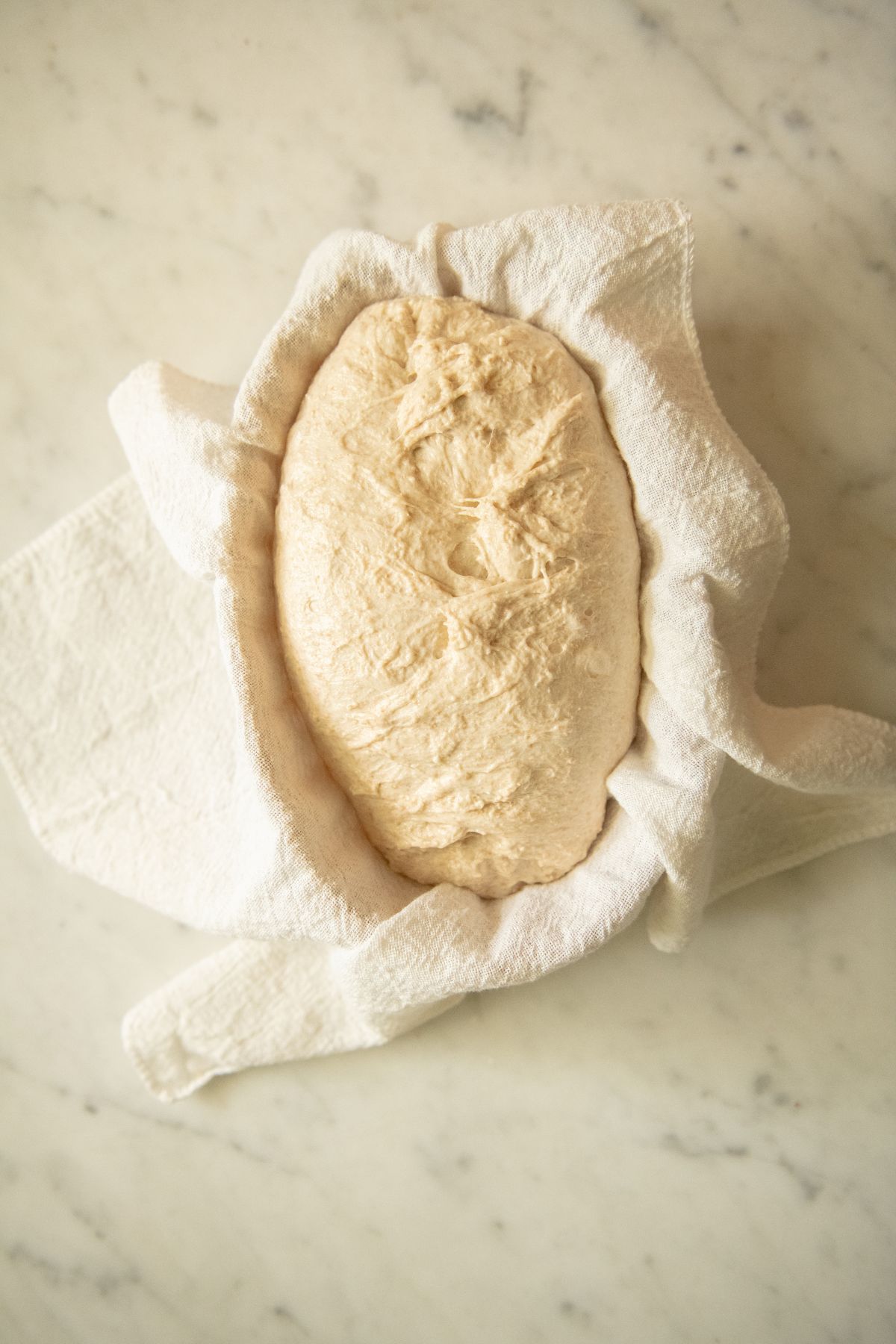 Spelt sourdough shaped in a towel basket.