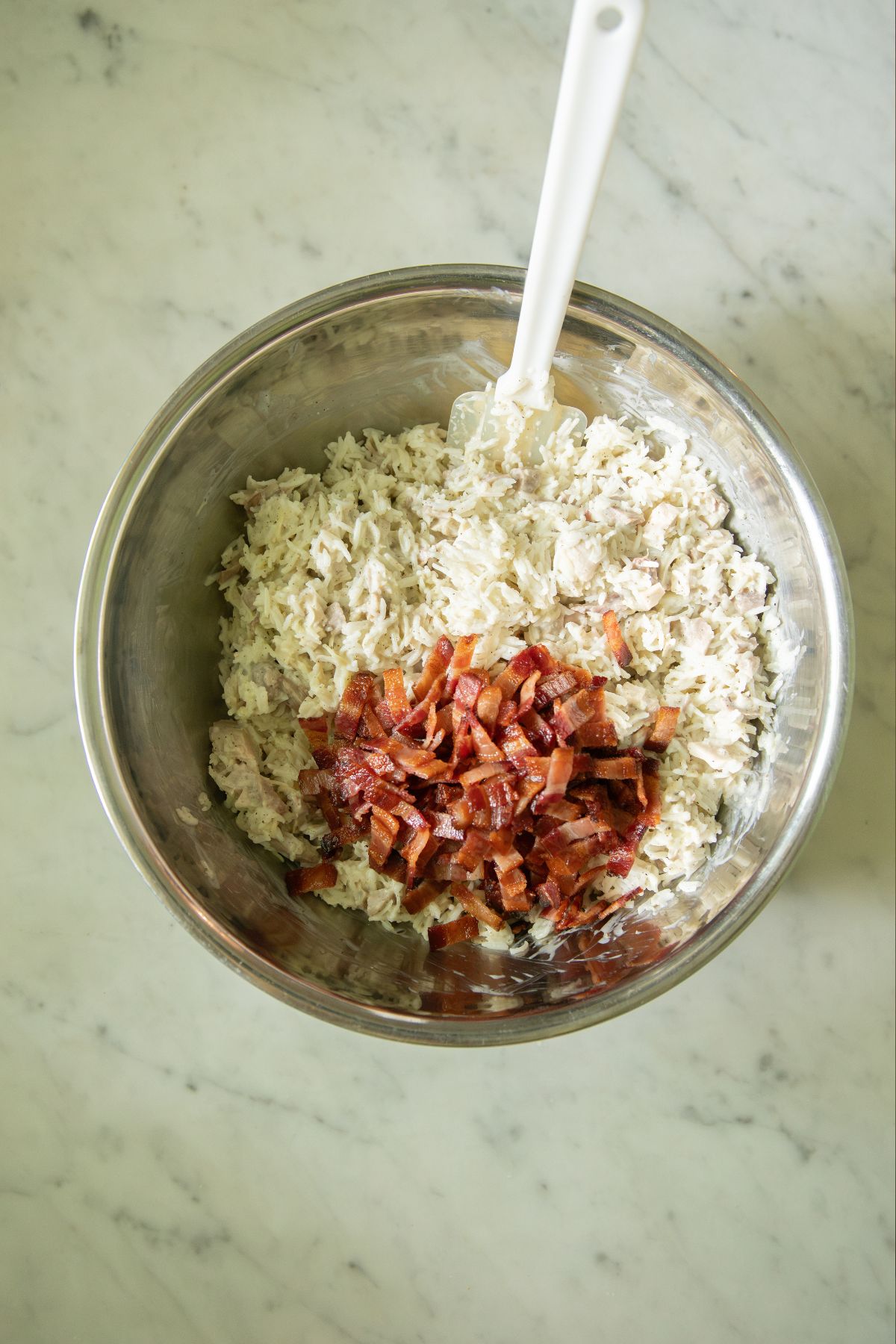 Stirring bacon into creamy rice.