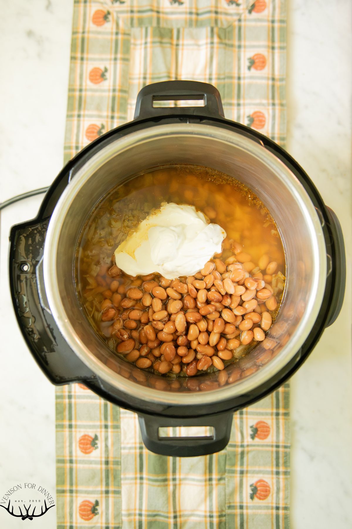 Beans and sour cream stirred into chili.