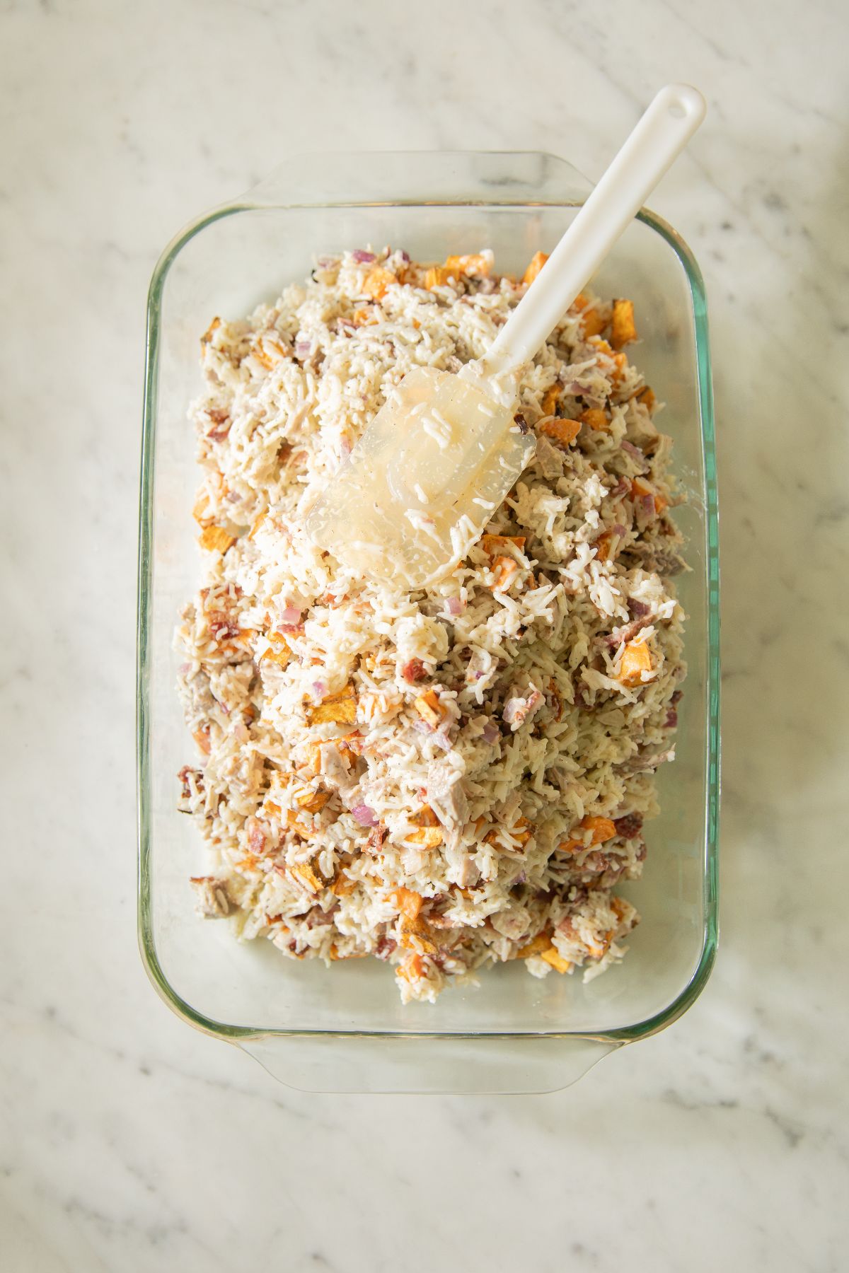 Spreading casserole out in a baking dish.