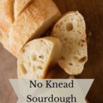 No knead sourdough baguette sliced on a board.