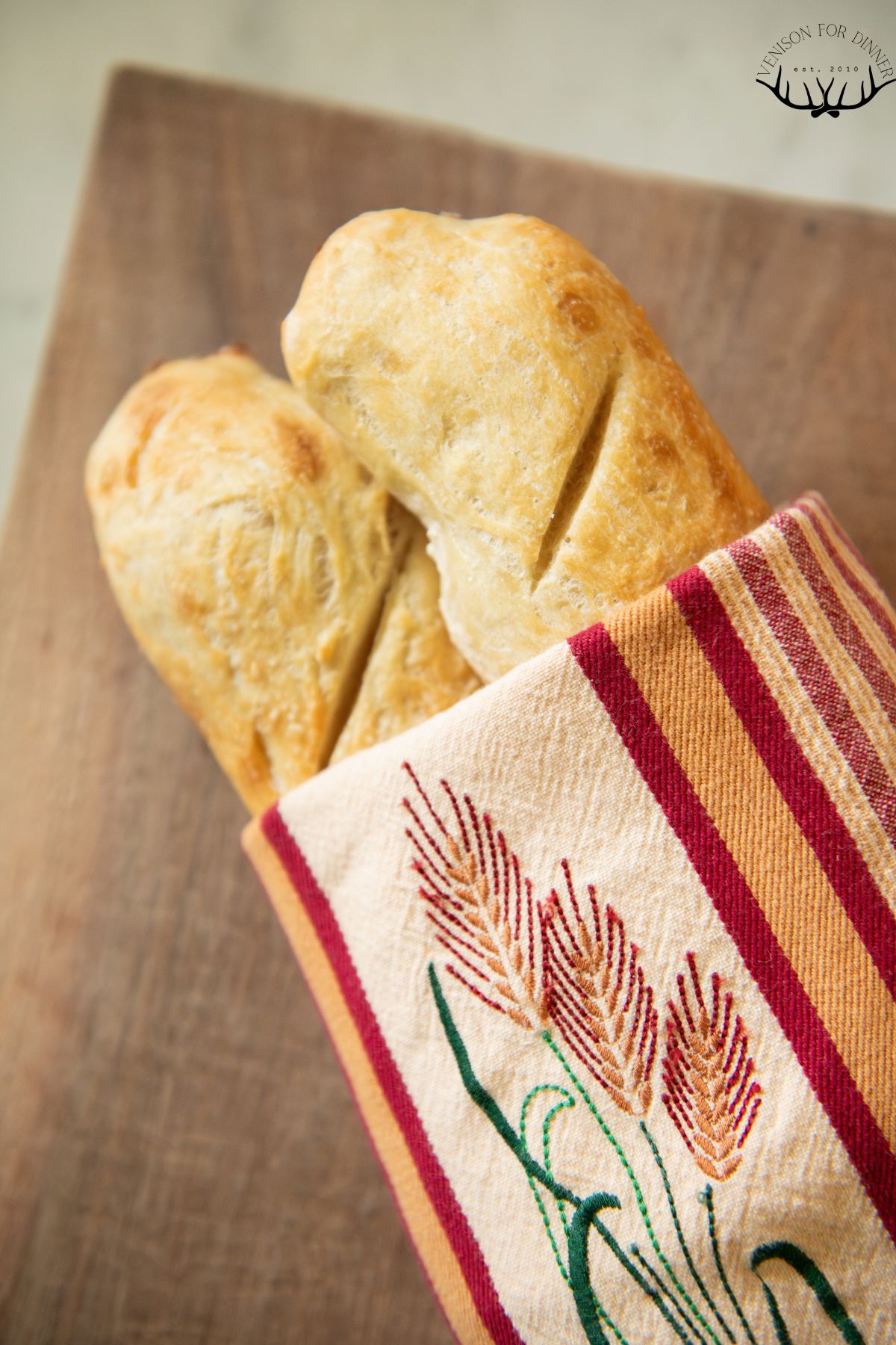 Sourdough baguette wrapped in a towel.