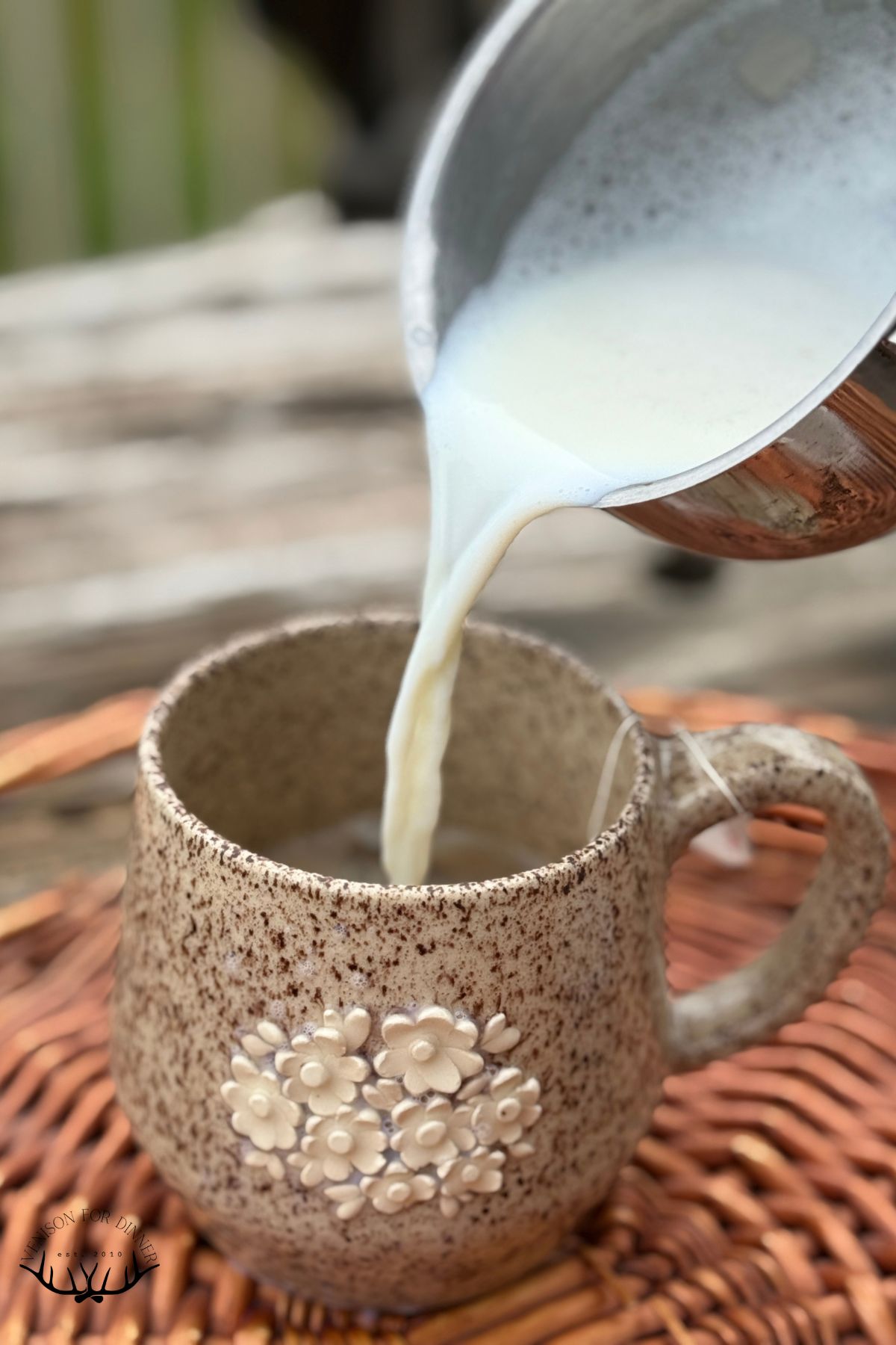 Pouring steamed milk into chai tea.